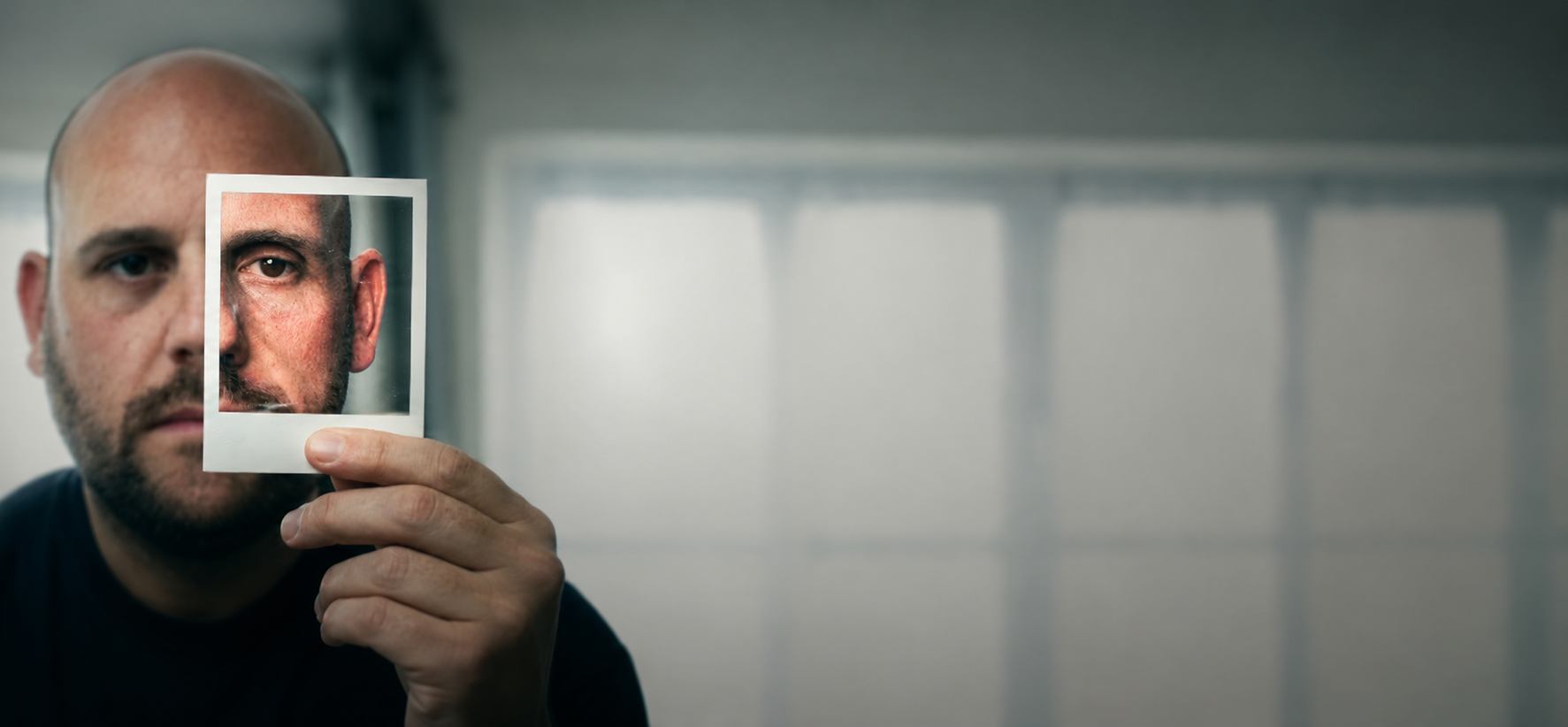 Toby Hoare holding a portrait of his post-transformation self