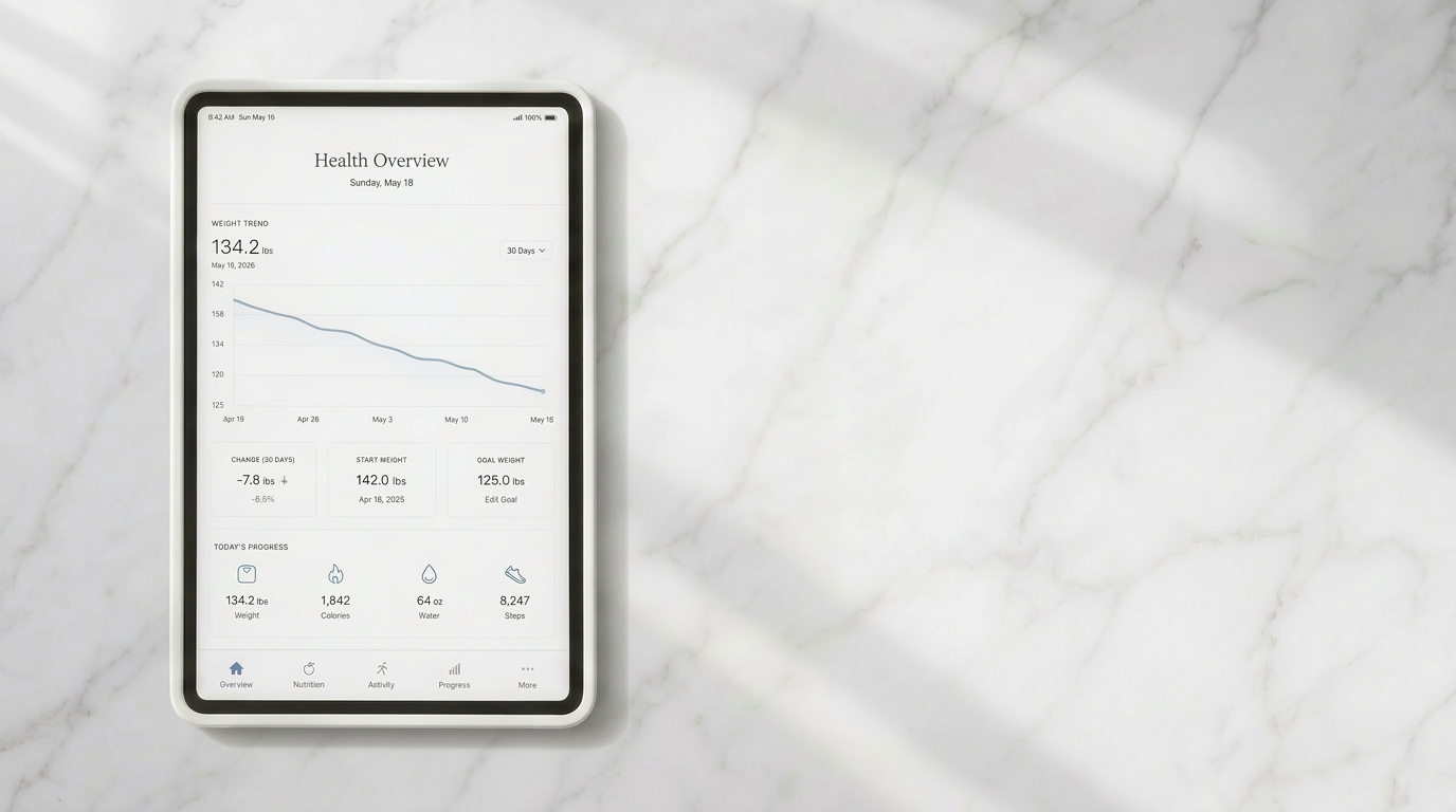An iPad displaying a minimalist health dashboard on a white marble worktop, illustrating how data-led mentoring tracks vital metabolic health metrics